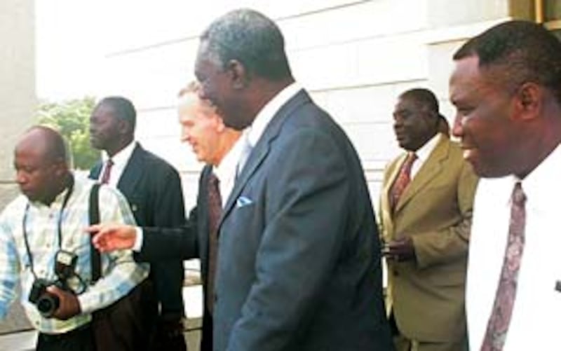Ghana President John A. Kufour, center, is accompanied by Elder Sheldon F. Child.