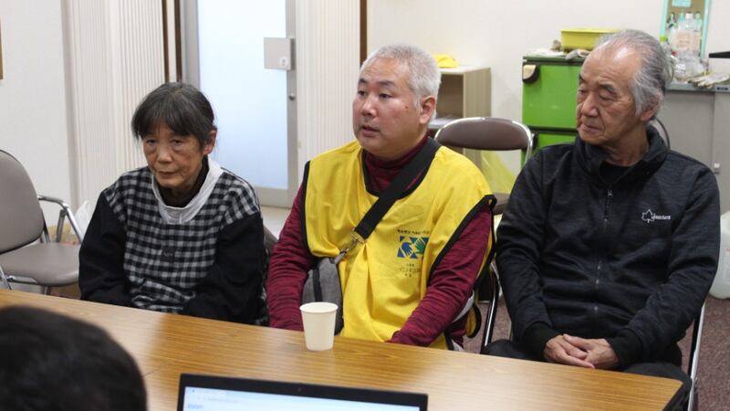 Two men and a woman sit at a table to discuss disaster relief and response to the Noto Peninsula earthquake in Japan.