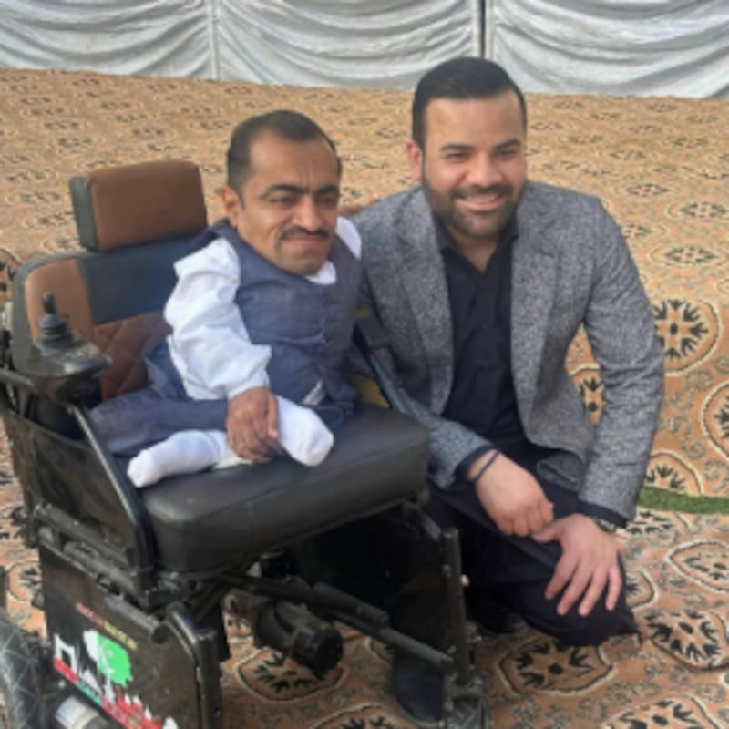 Pakistan Minister of State Barrister Aqueel Malik poses with a wheelchair beneficiary during a handover event on February 13, 2026, in Taxila City, Pakistan.