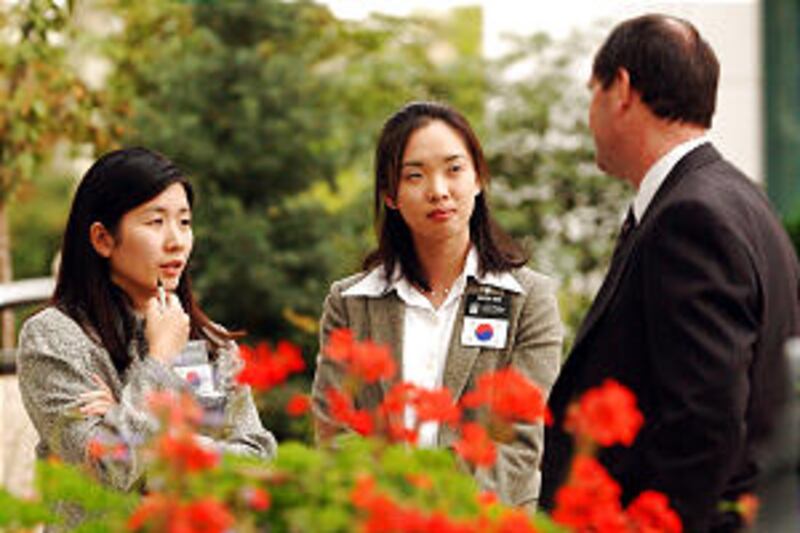 Sister missionaries Joohee Won and Minsun Choi talk during LDS General Conference Oct 5th, 2002. A