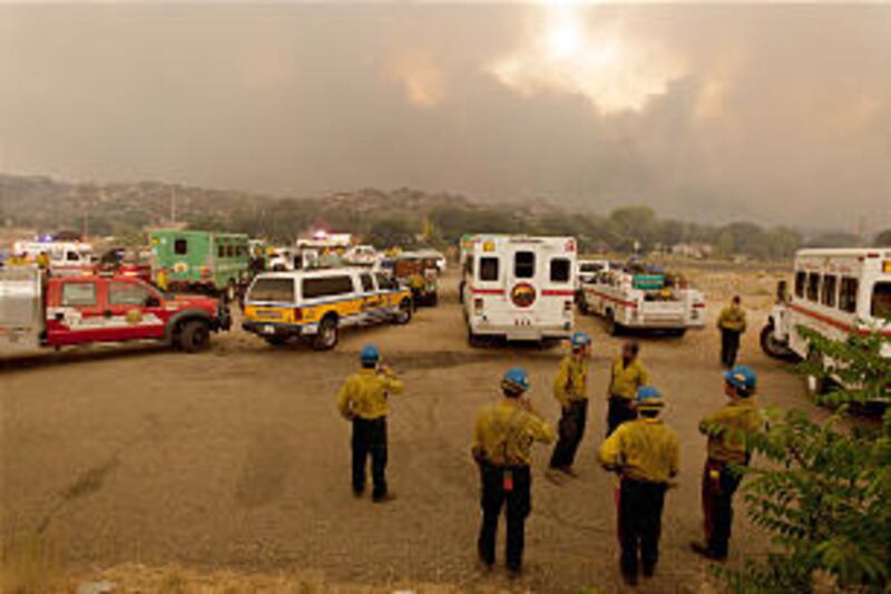 Members of the US Forest Service's Blue Ridge Hotshots, foreground, and other firefighters watch as