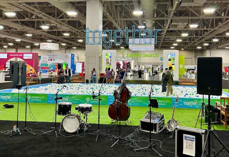A sign featuring the word "Together" the theme for RootsTech 2026, hangs in the expo hall.