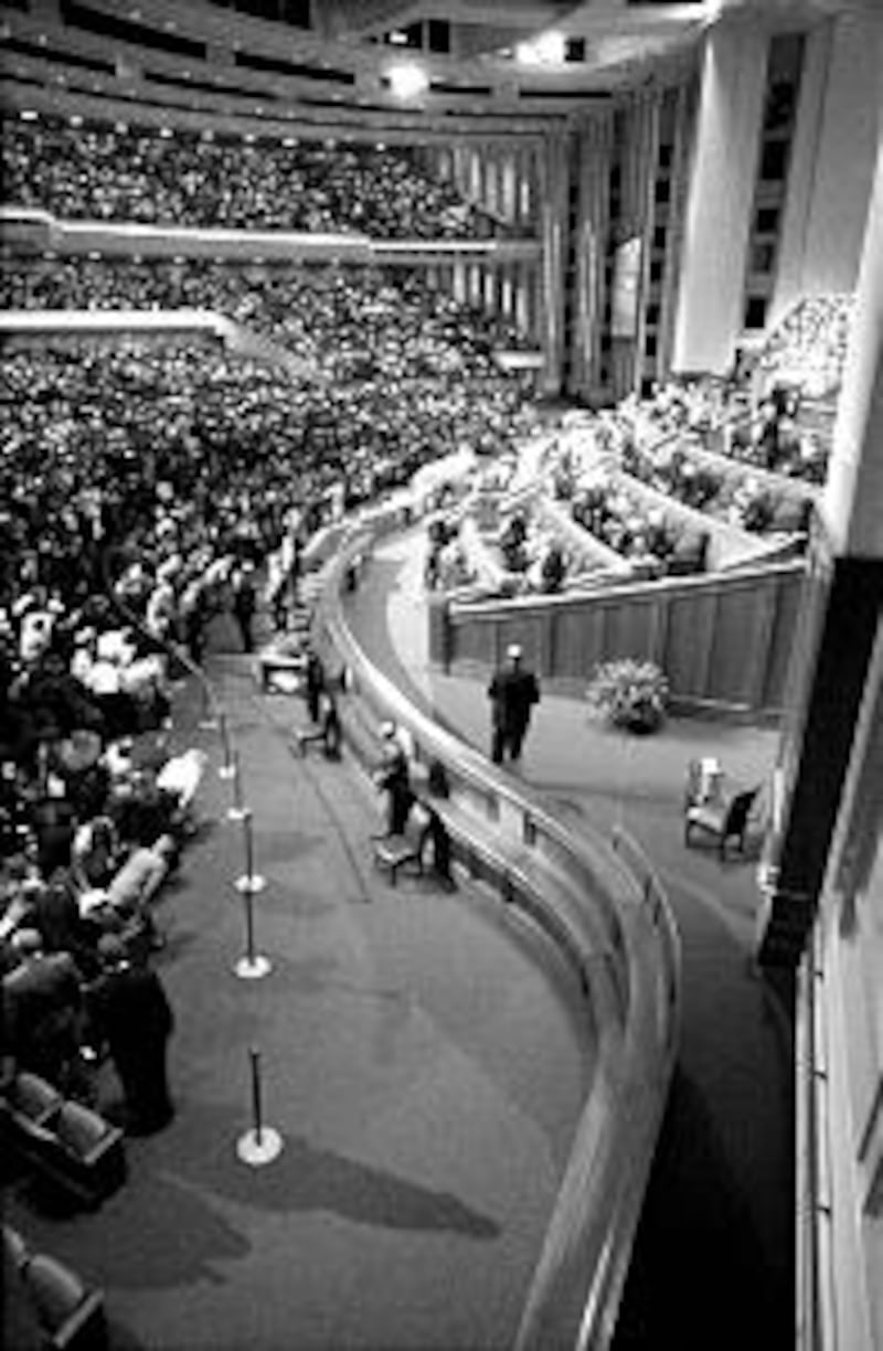 Conference-goers stand to sing intermediate hymn during the Saturday morning session.