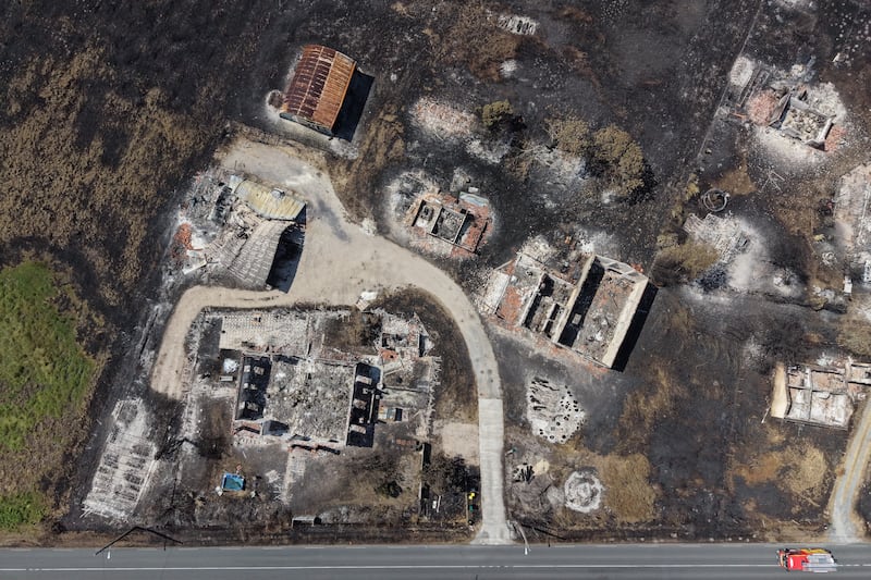 This aerial shot taken by a drone shows burned houses and ground after wildfires raged near the village of Le Porge, Southwestern, France, Monday, July 27, 2026.