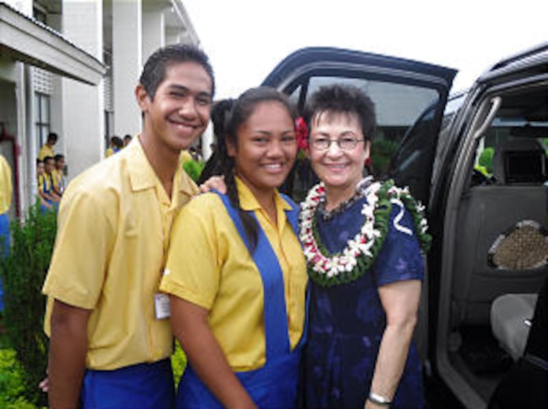 Sister Harriet Uchtdorf makes a pair of new friends at the Church-owned college in Pesega, Samoa. Th