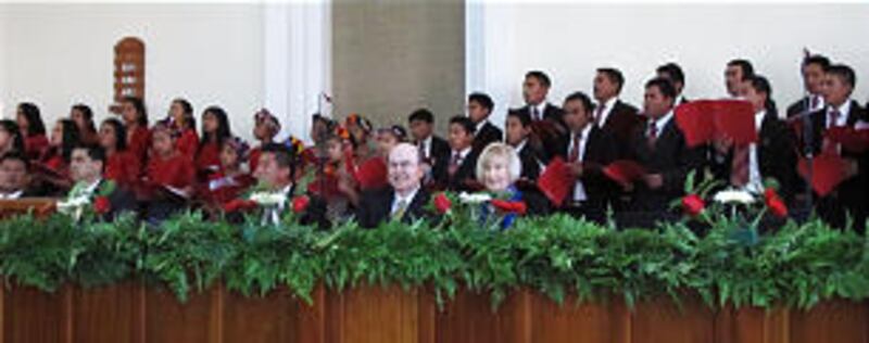 Elder Quentin L. Cook and Sister Mary Cook are seated together at a special stake conference in Momo