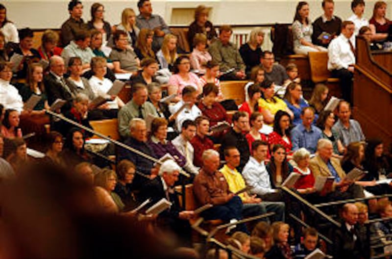 Audience members join with the choir in singing. A combined student choir from BYU-Idaho finishes th
