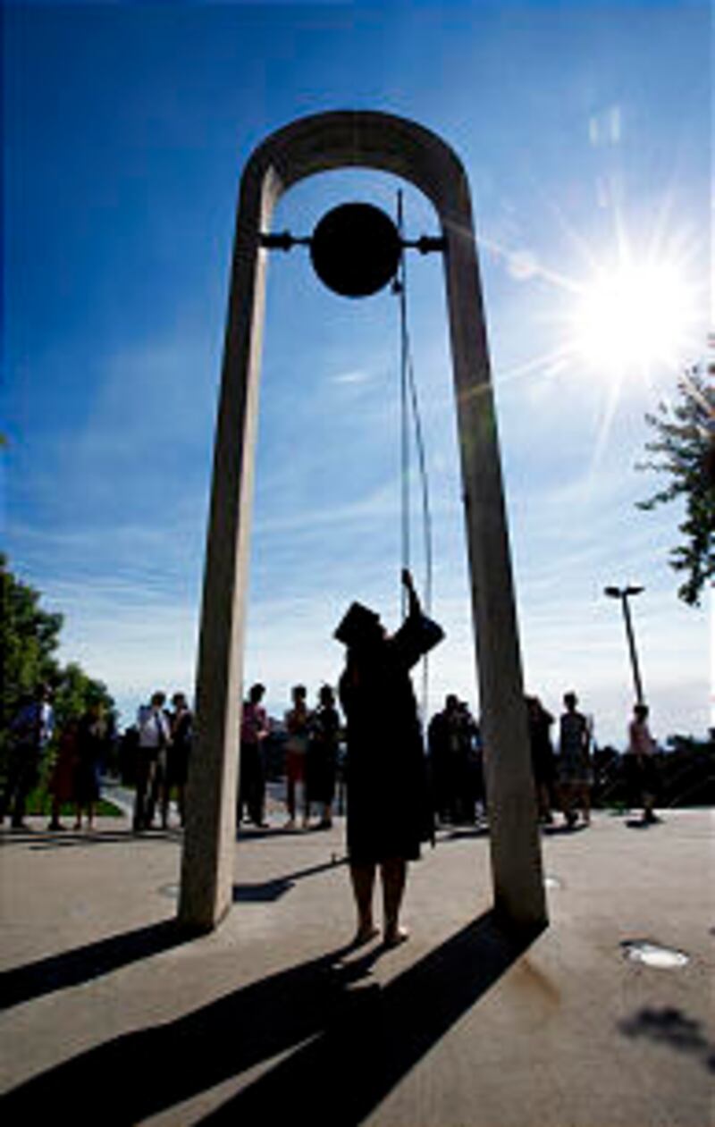 A BYU Graduate rings the victory bell after the BYU Summer Commencement Exercises.