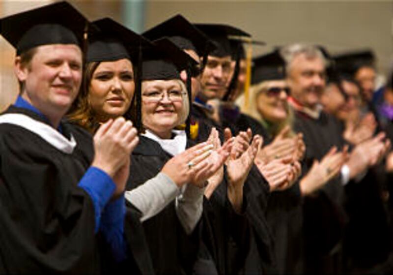 Faculty and staff applaud the LDS Business College Class of 2011 as they walk in a procession throug
