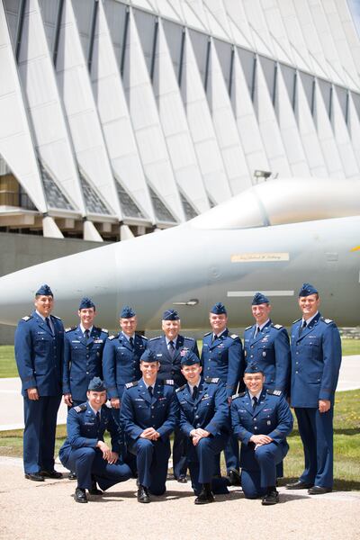 Elder Bruce A. Carlson, a retired Air Force general and an emeritus Seventy, joins several Latter-day Saints cadets on the grounds of the U.S. Air Force Academy.