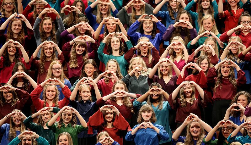 Members of the Young Women Choir from Stakes in Pleasant Grove form hearts with their hands as Presi