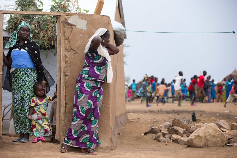 Refugees stand outside of shelters and gather as a visitor comes to the Minawao Refugee Camp in northern Cameroon, Monday, April 18, 2016.