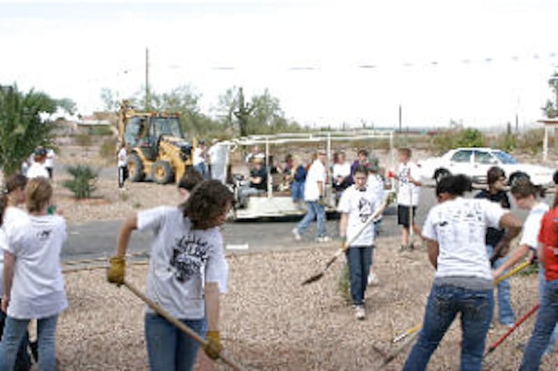 Gilbert Arizona stake youth join youth from the Catholic Church to perform community service. Backho