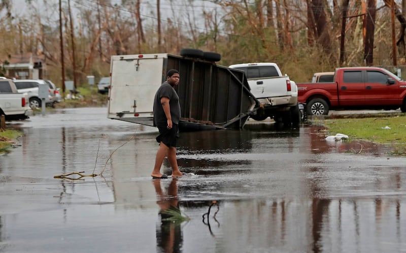 A man walks in the street of his heavily damaged neighborhood in the aftermath of Hurricane Michael in Panama City, Fla., Wednesday, Oct. 10, 2018. Supercharged by abnormally warm waters in the Gulf of Mexico, Hurricane Michael slammed into the Florida Panhandle with terrifying winds of 155 mph Wednesday, splintering homes and submerging neighborhoods. (AP Photo/Gerald Herbert)