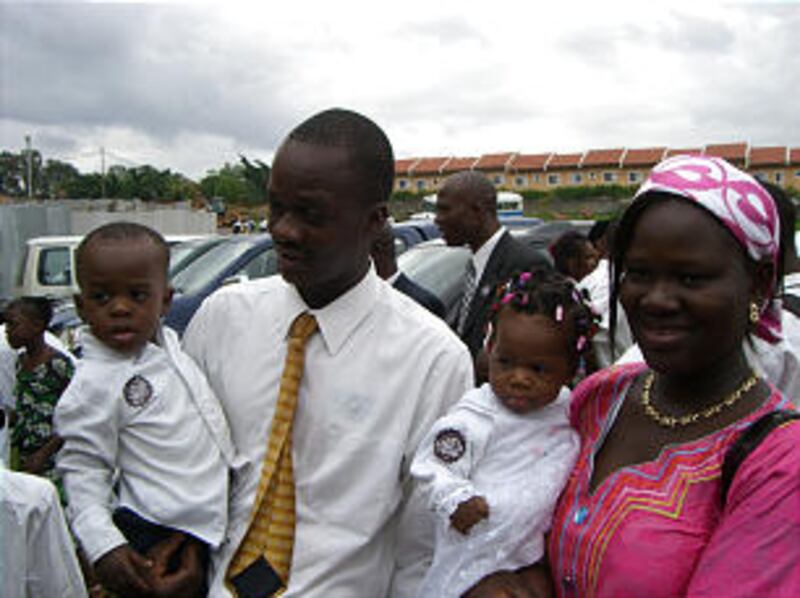 A young family gathers for meetings outside Church building in Kinshasa, DR Congo, that included tra