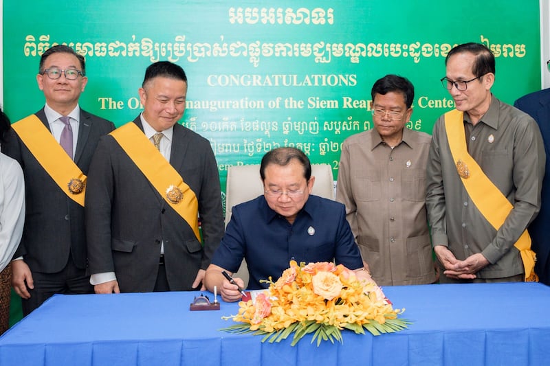 Chheang Ra, Cambodian minister of health, center, with Elder Benjamin M.Z. Tai, General Authority Seventy and the Asia Area president, center left, signs commemorative book at the ceremony celebrating the new heart center.