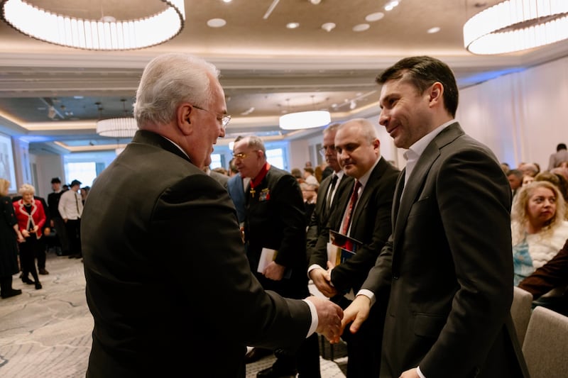Elder Jack N. Gerard, a General Authority Seventy and first counselor in the Church's Europe Central Area Presidency, greets Ciprian Olinici, Romania’s State Secretary for Religious Affairs, at the Romanian Bucharest District Conference on Feb. 22, 2026.