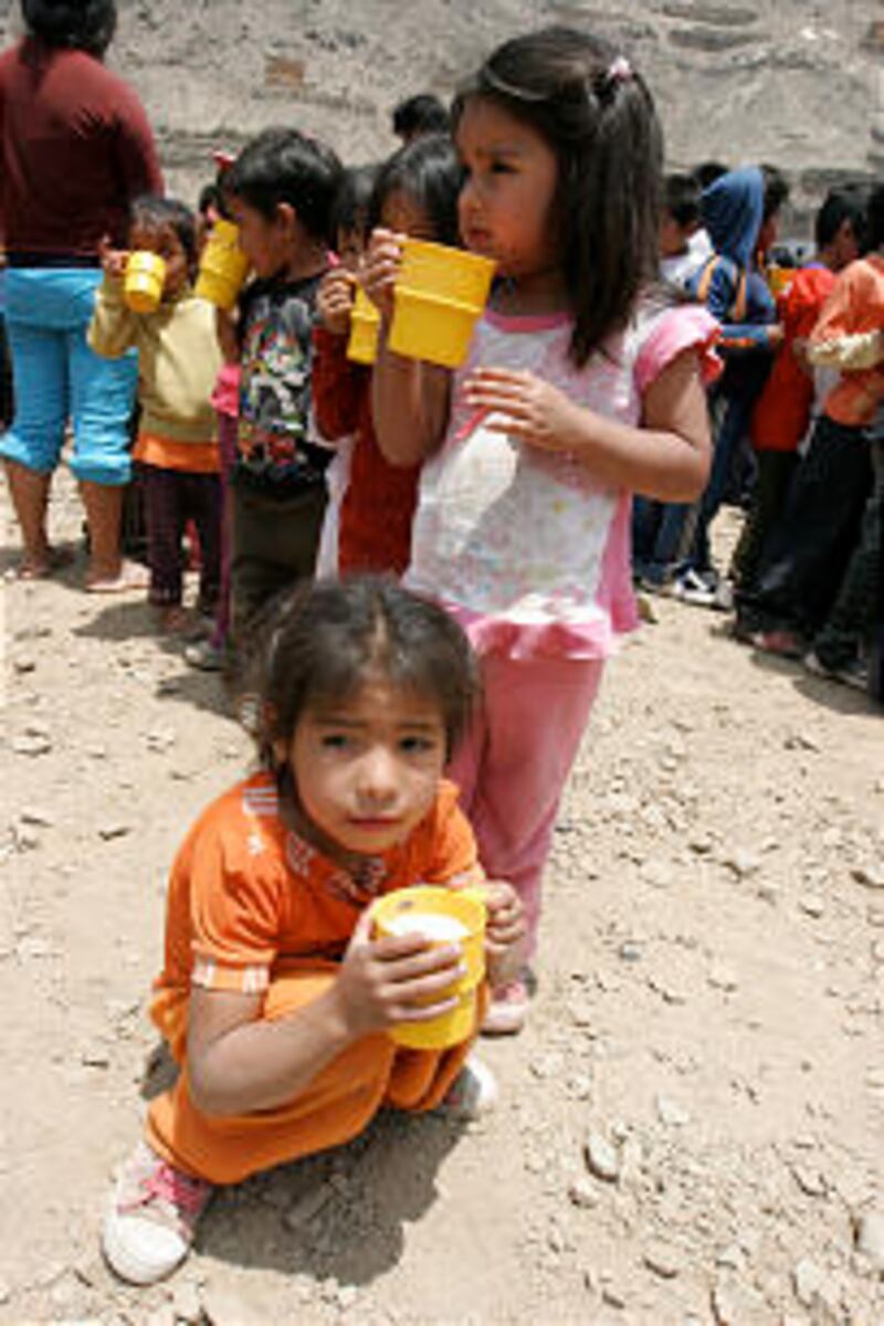 Young girls fill up on a hot breakfast of apple oatmeal and bread in their hillside community above
