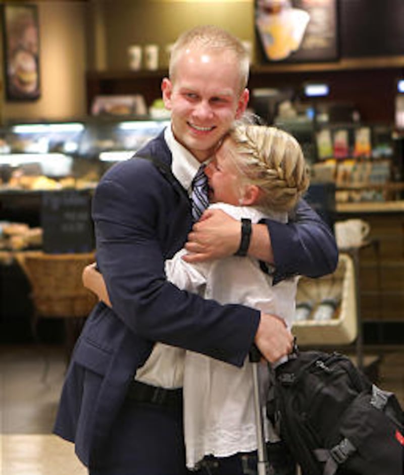 Elder Wayne Owens hugs his sister, Emmeline, to welcome him home to Salt Lake City from serving two