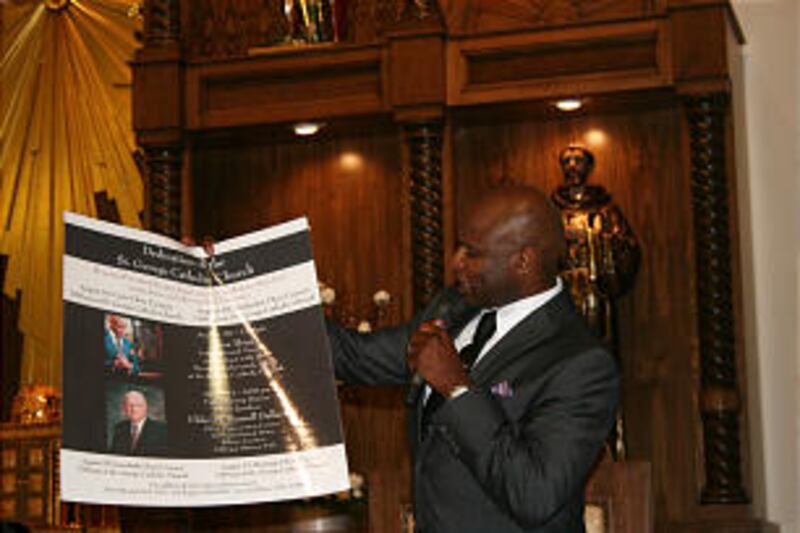 Following his concert, Mormon Tabernacle Choir member Alex Boye displays a poster advertising dinner