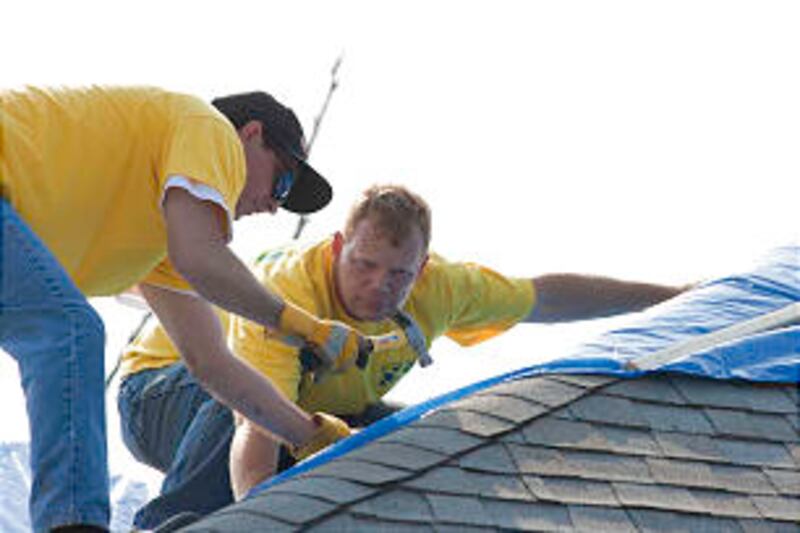 Helping Hands volunteers secure tarp to roof in Joplin, Mo. More volunteers will converge on Joplin