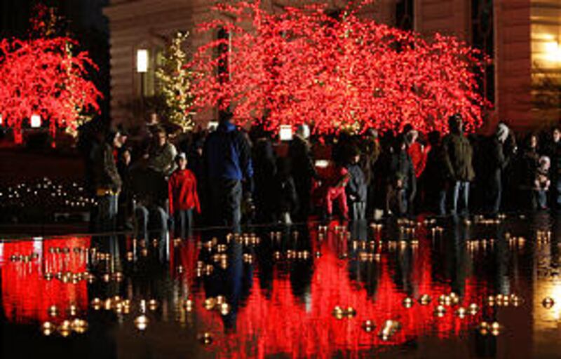 Downtown visitors walk through the Main Street Plaza as Christmas lights are turned on downtown an
