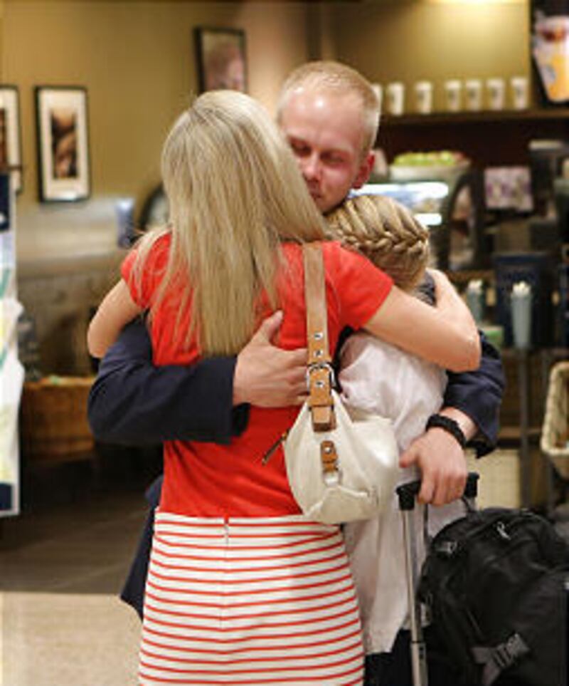 Elder Wayne Owen gets a hug from his mother, Cynthia, and sister, Emmeline, as they welcome him home