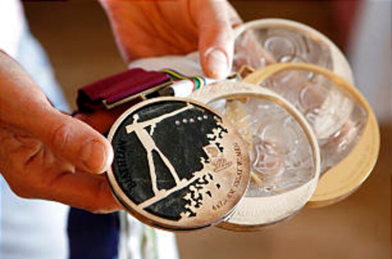 Antje Harvey holds her four Olympic medals: one gold and two silver medals from the 1992 games and o