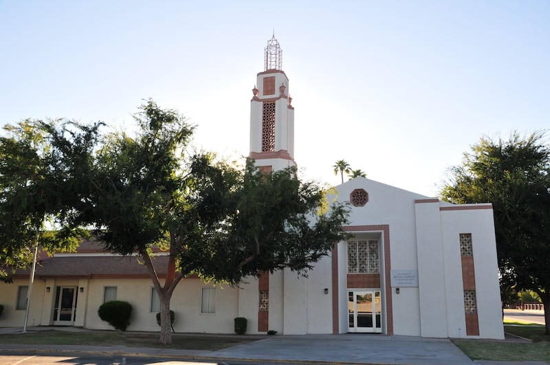 A white chapel surrounded by trees in Mesa, Arizona.