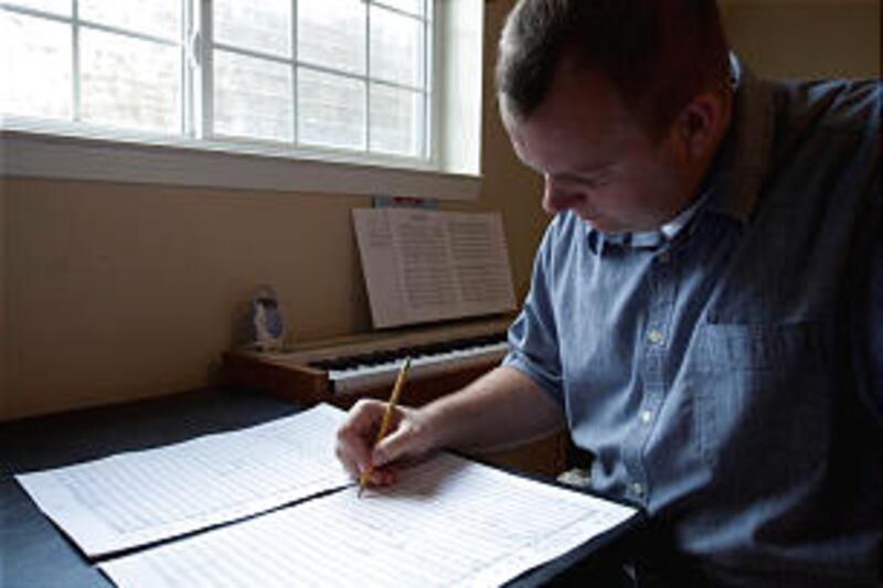 Fulbright winner Doug Pew often composes music at home with piano, laptop, and composition paper sur