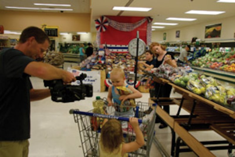 RJ Hill, left, videotapes the Chase family as they shop at the Army Commissary on the Fort Hood Army