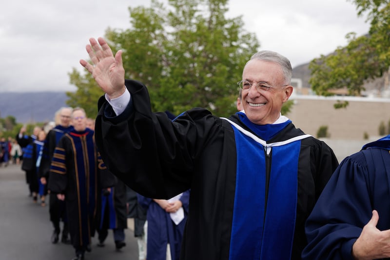 Elder Ulisses Soares of the Quorum of the Twelve Apostles waves to the line of BYU graduates outside the Marriott Center on Thursday, April 23, 2026, in Provo, Utah.