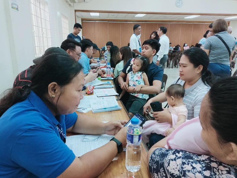 Parents hold their children in the Pasay Philippines Stake Center during a child nutrition screening on April 18, 2026.