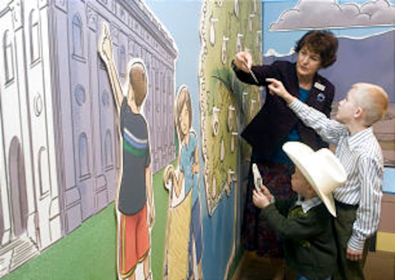 At the Church History Museum, docent Maureen Brandon plays a game with Howard Brignone, 4, and broth