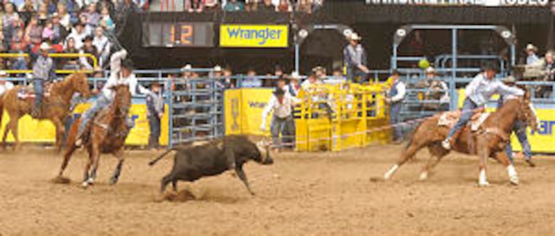 Roping Randon Adams, left, and Matt Sherwood team up to rope a steer in December at the 2008 Wrangle